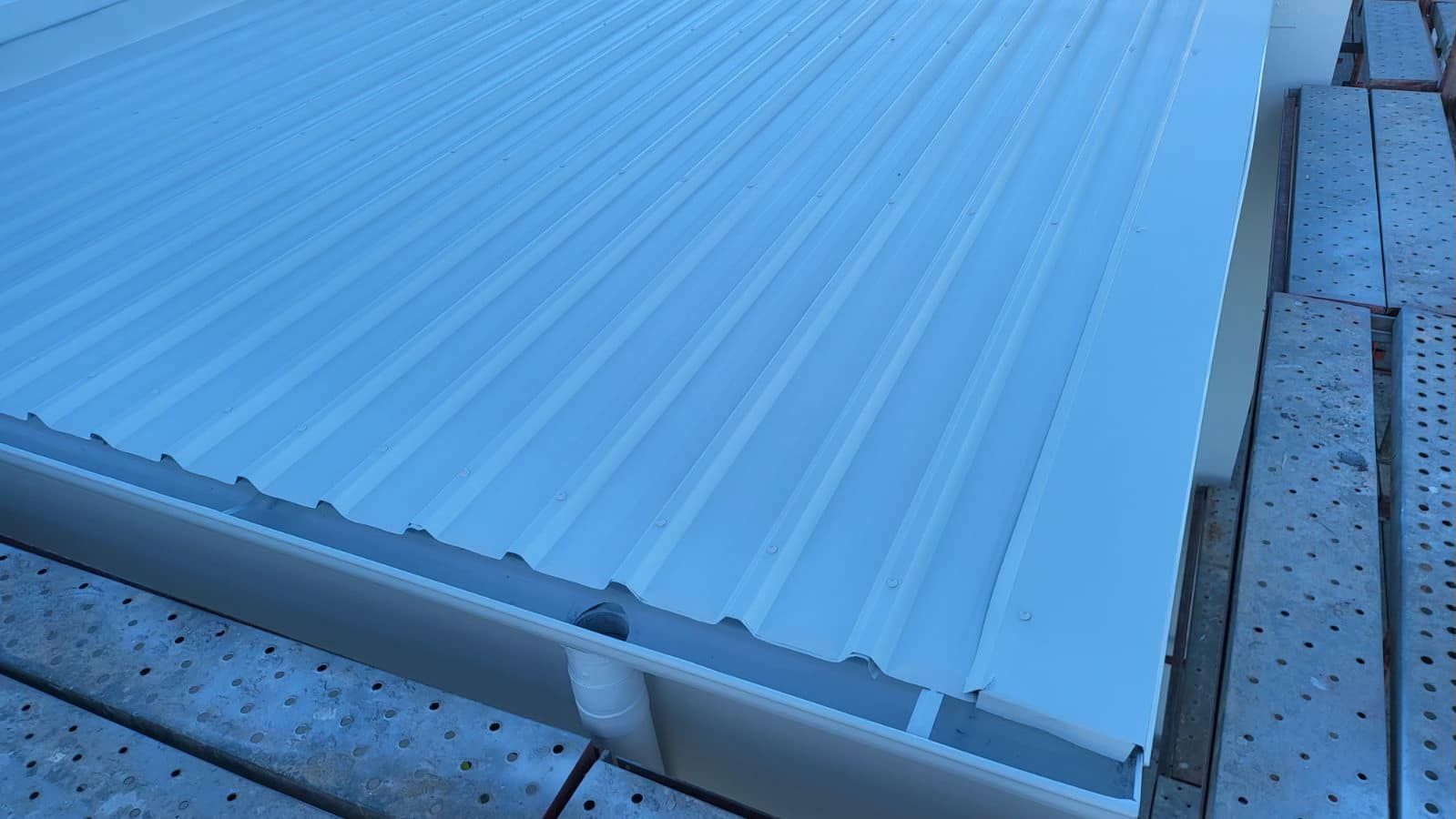 A white metal roof is sitting on top of a concrete floor. — Roofing Gold Coast in Tallebudgera, QLD