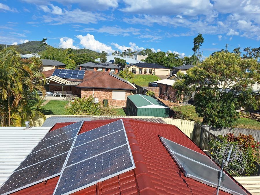 A House With a Red Roof and Solar Panels on It — Roofing Gold Coast in Tallebudgera, QLD
