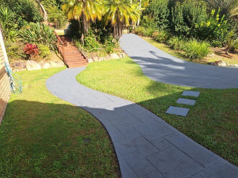 A Driveway Leading to a House in a Lush Green Garden — Roofing Gold Coast in Tallebudgera, QLD