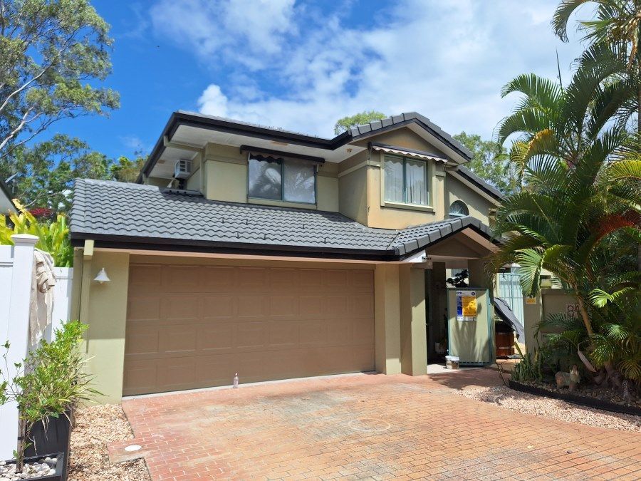 A Large House With a Garage and a Driveway in Front of It — Roofing Gold Coast in Tallebudgera, QLD