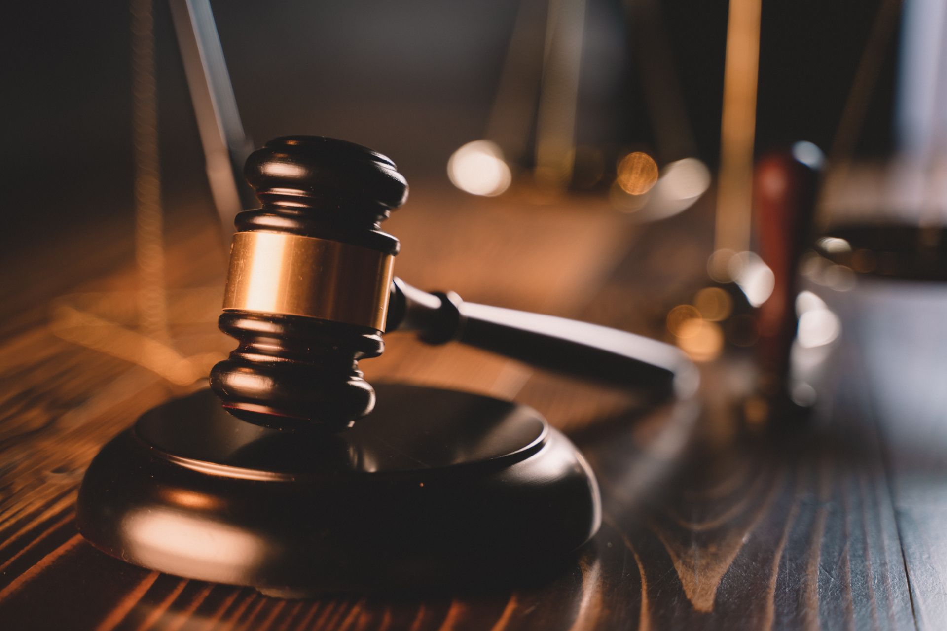 A close up of a judge 's gavel on a wooden table.