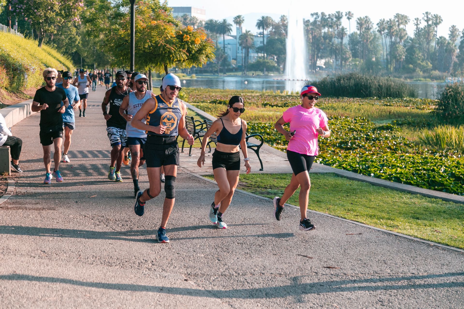A group of people are running on a path in a park.