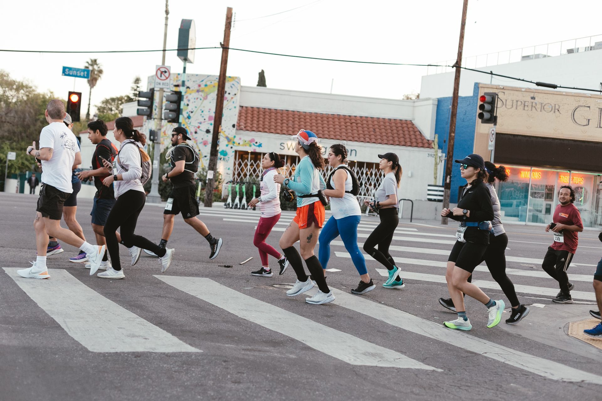 A group of people are running across a crosswalk.