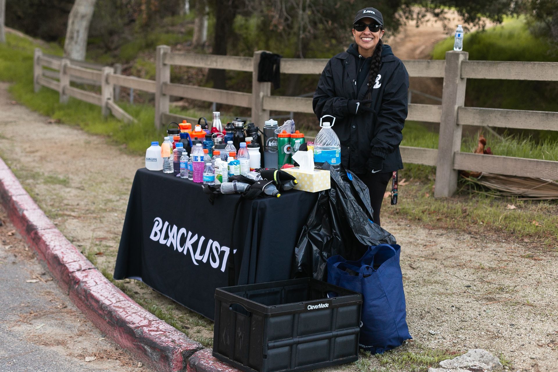 A woman is standing next to a table that says blacklist on it