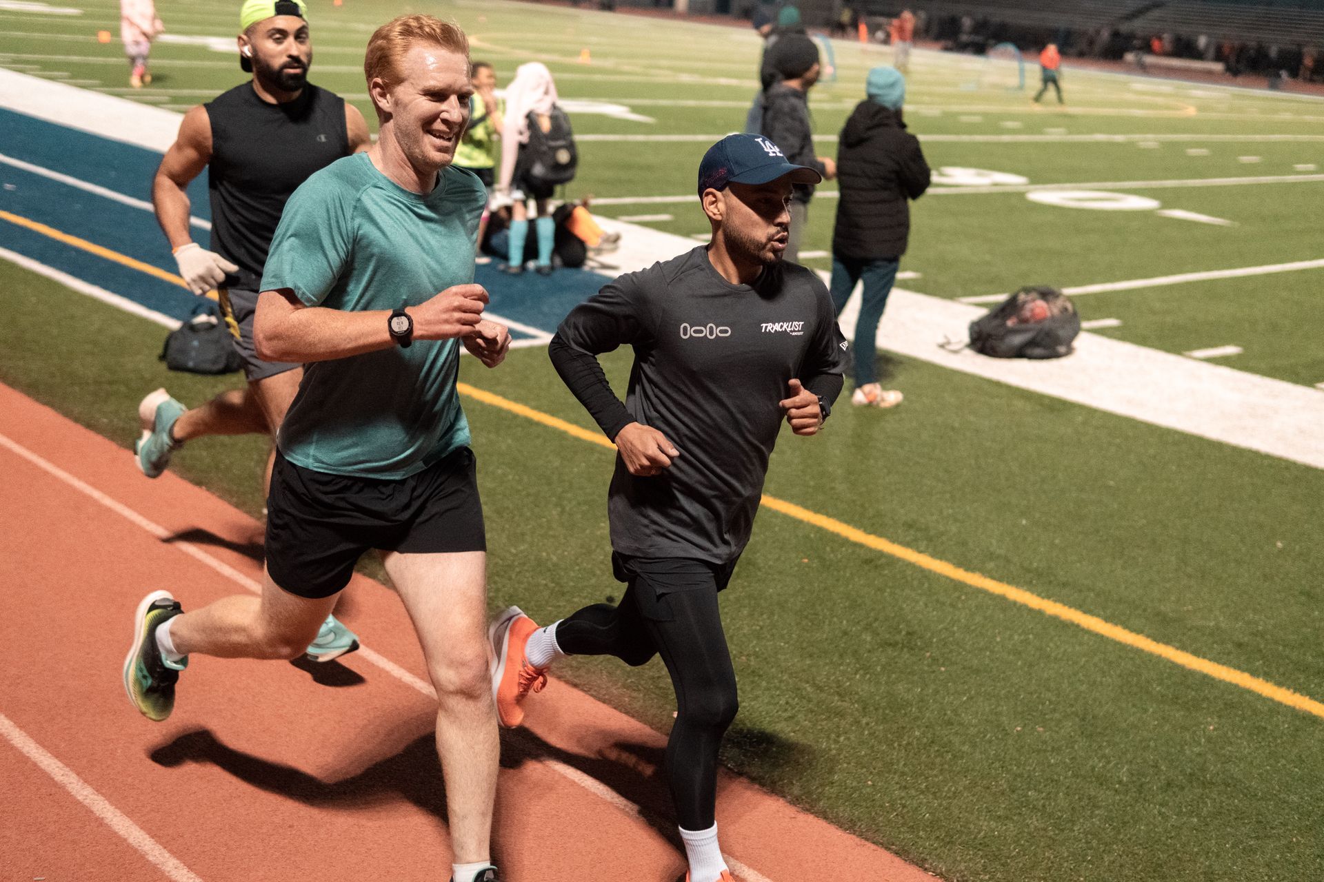 trio of runners having fun while doing laps on a track