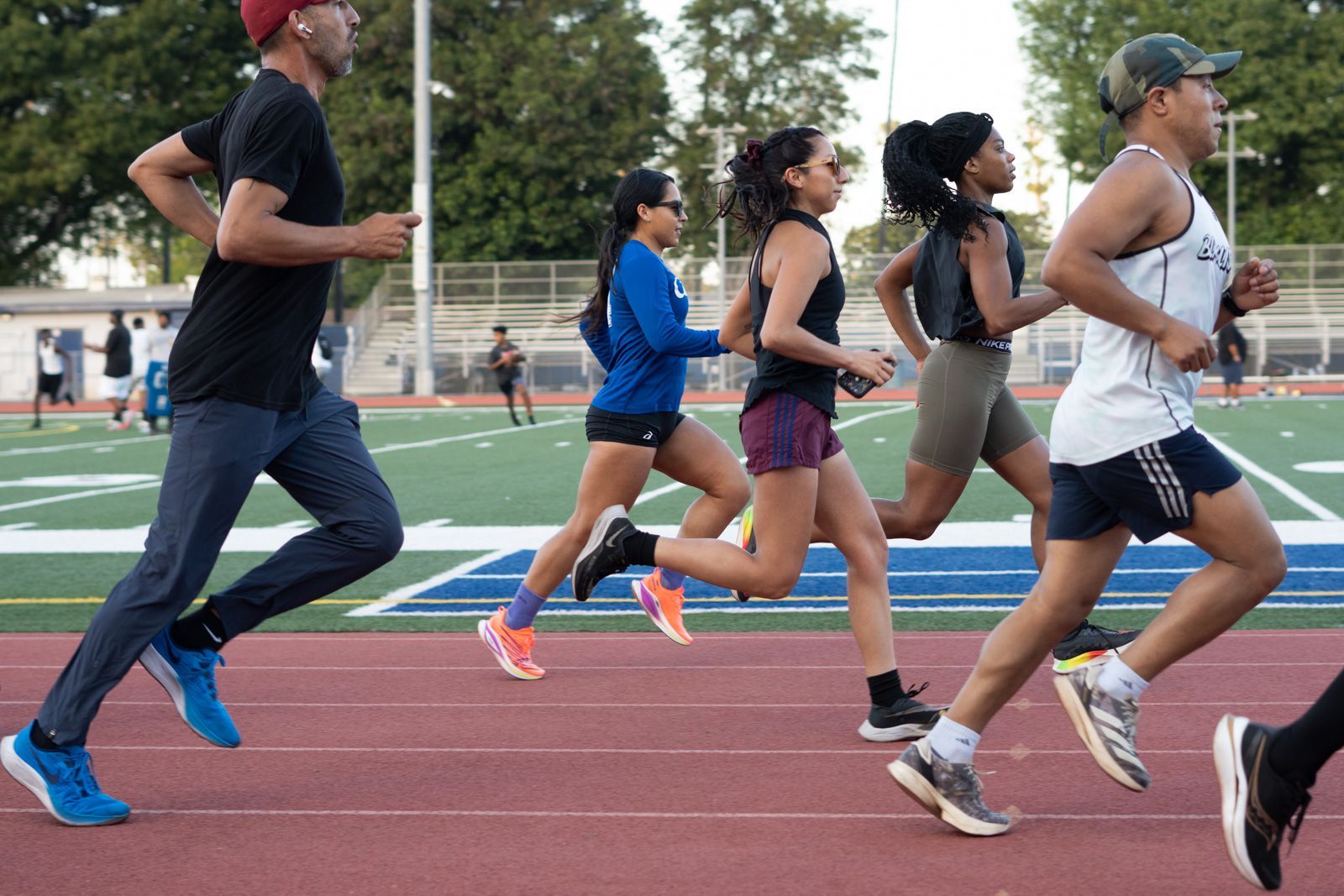 A group of people are running on a track.