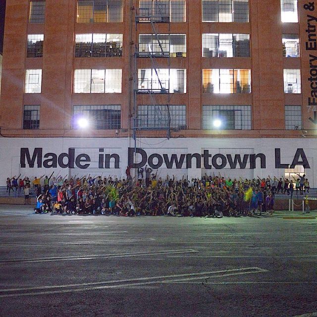 A large group of people are gathered in front of a building that says made in downtown la