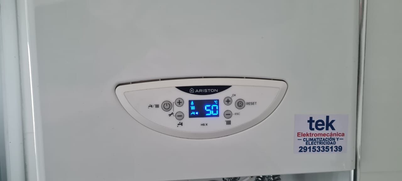 Caldera blanca con pantalla digital que muestra el número 50. A la derecha se ve una pegatina con el texto 