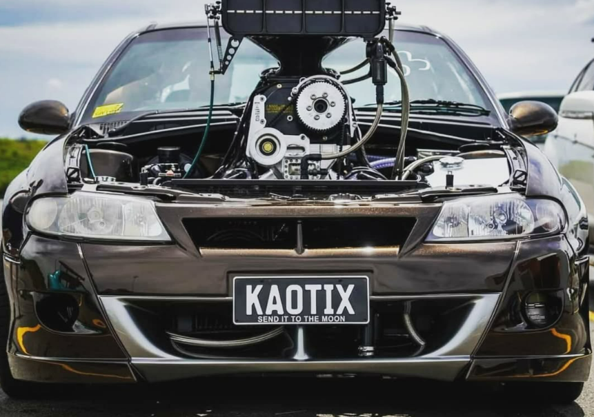 A Black Car With the Hood Up and a License Plate That Says Kaotix — South Coast Radiators In Southern Highlands, NSW