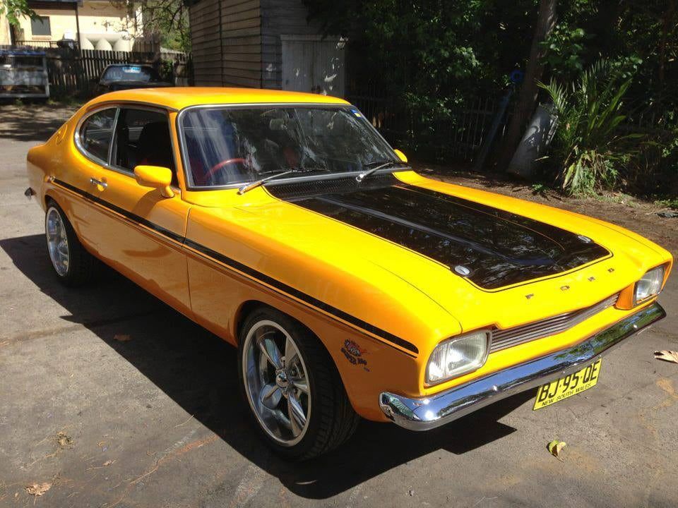 A Yellow Car With a Black Hood is Parked in a Driveway — South Coast Radiators In Woonona, NSW