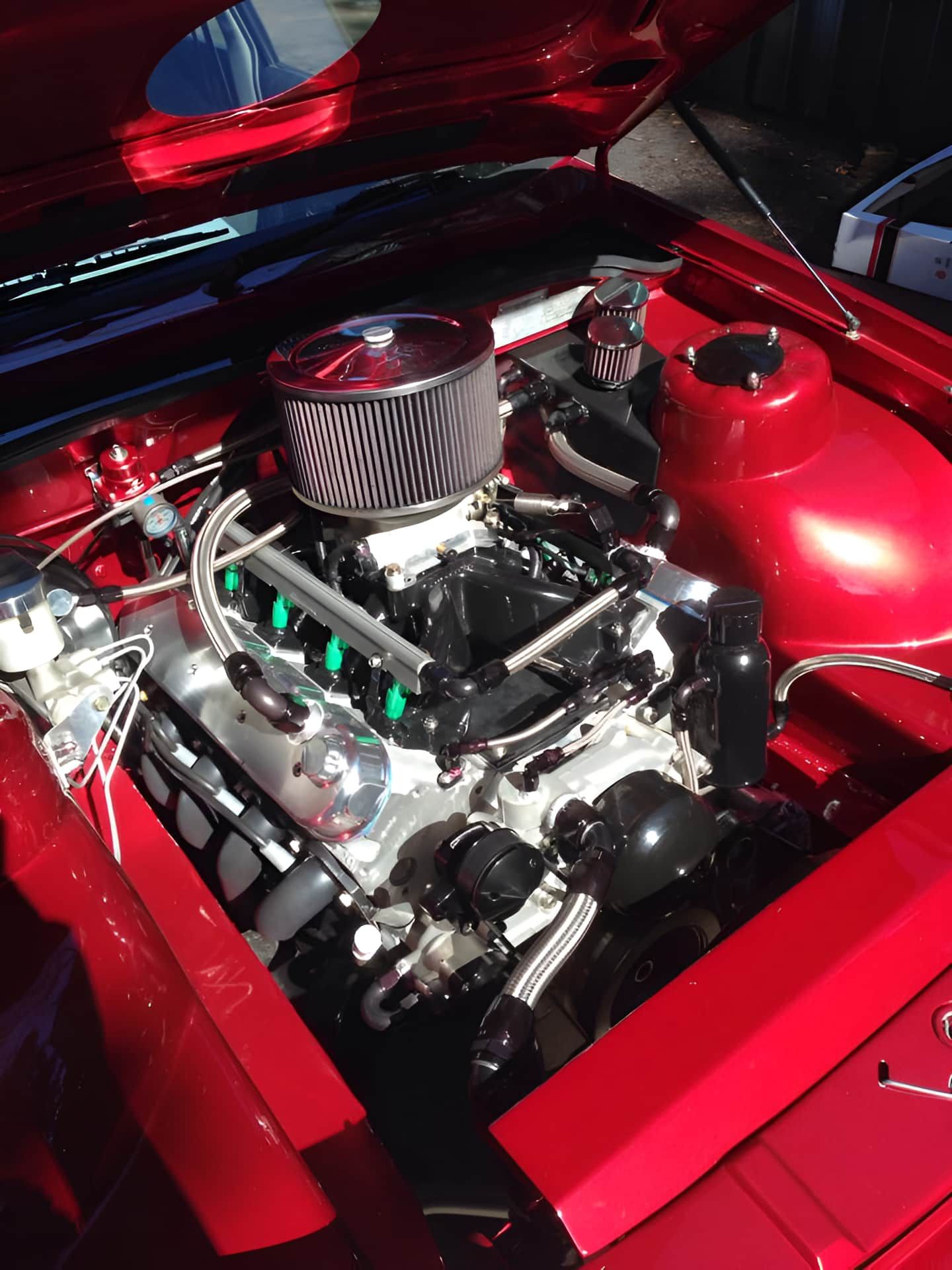 A Close Up of a Red Car Engine With the Hood Open — South Coast Radiators In Woonona, NSW