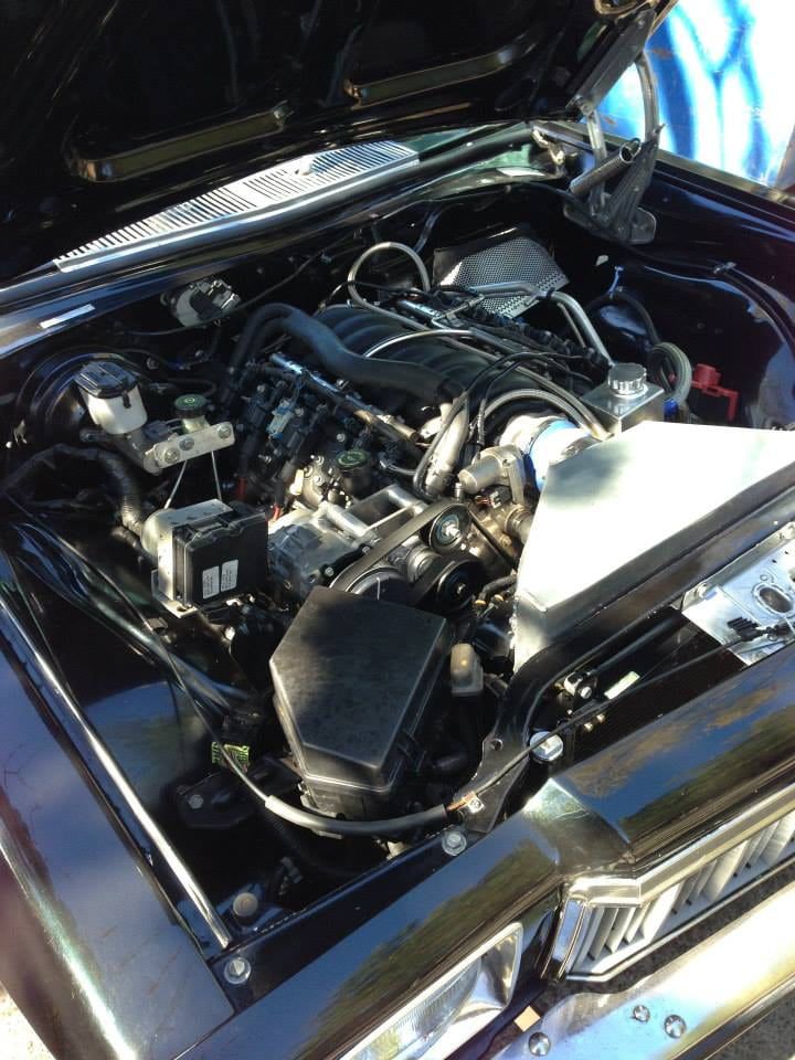The Engine of a Black Car is Shown With the Hood Open — South Coast Radiators In Wollongong, NSW