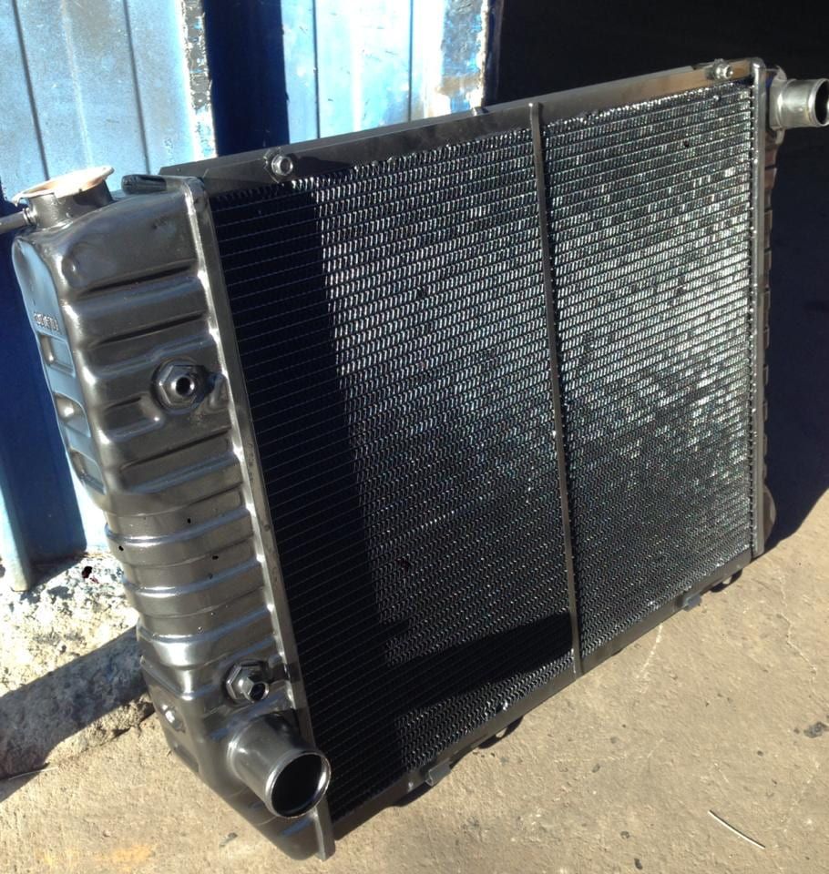 A Black Radiator is Sitting in Front of a Blue Building — South Coast Radiators In Woonona, NSW
