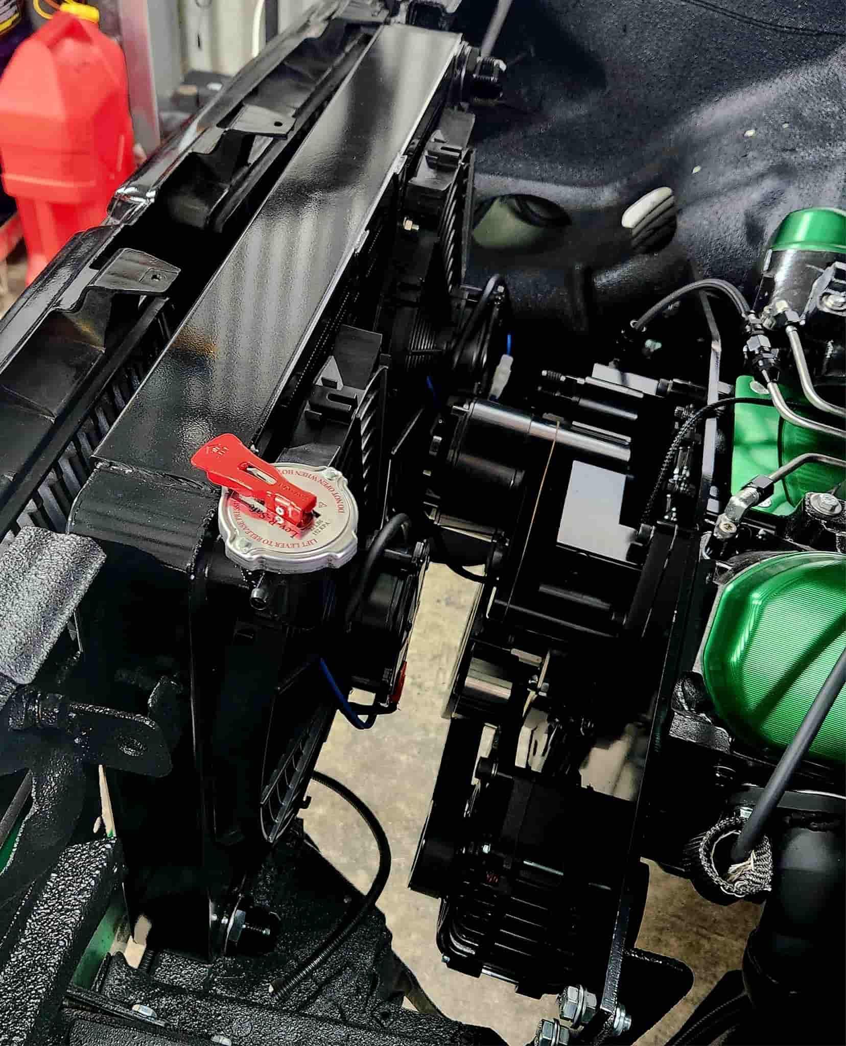 A Green Air Compressor is Sitting Under the Hood of a Car — South Coast Radiators In Wollongong, NSW