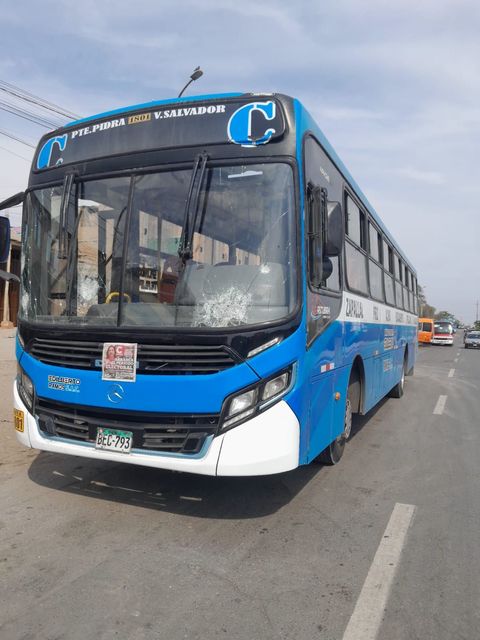 Un autobús azul y blanco está estacionado al costado de la carretera.