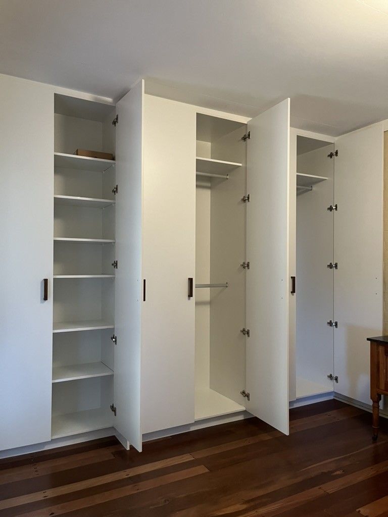 Room With a Wooden Floor and White Cabinets With the Doors Open — D Hinged Kitchens & Joinery in Ocean Shores, NSW