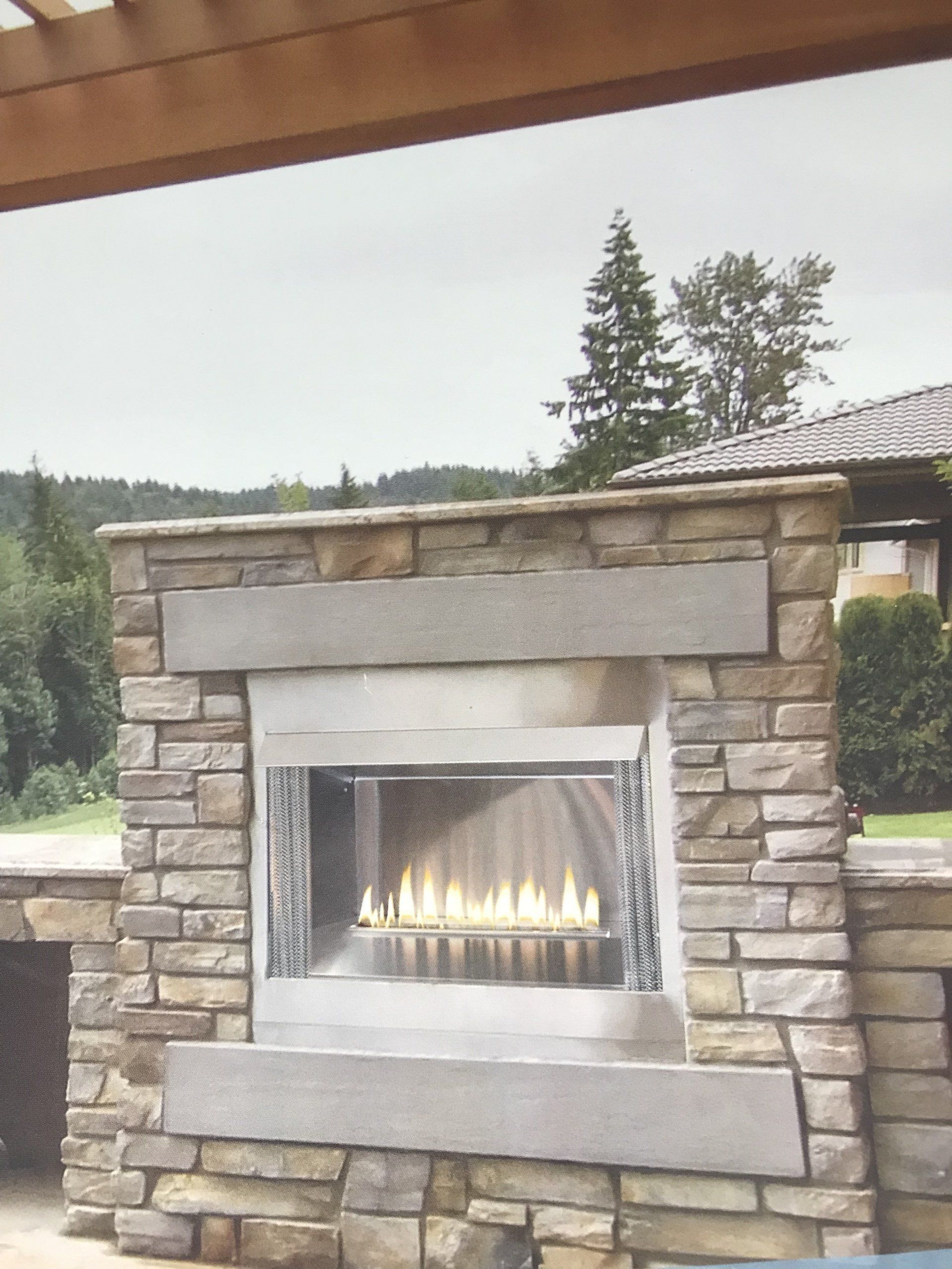 A stone fireplace with a stainless steel burner