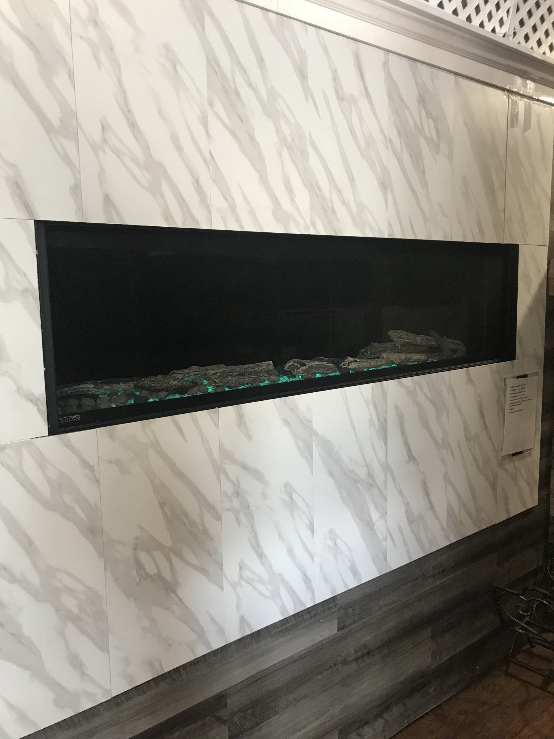 A fireplace is built into a marble wall in a living room.