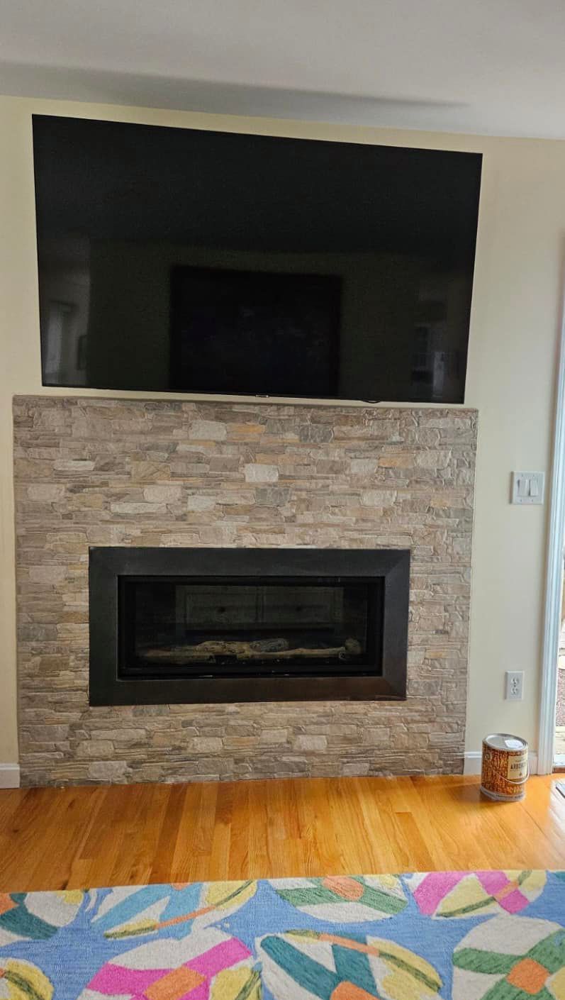 A living room with a fireplace and a flat screen tv.