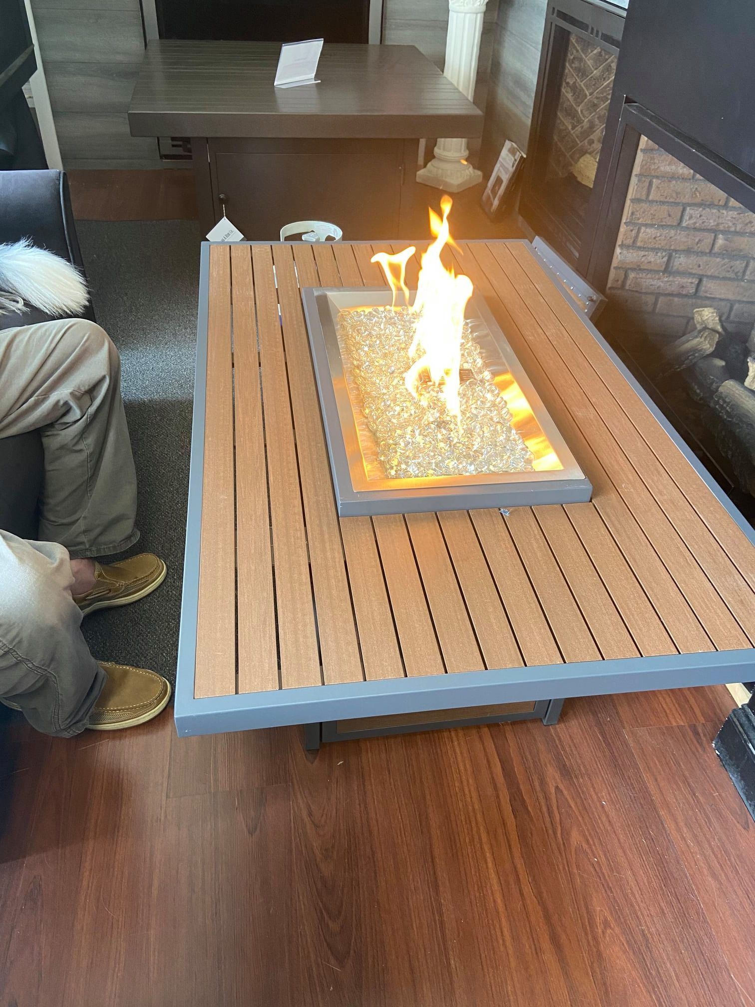 A fire pit is sitting on top of a wooden table in a living room.