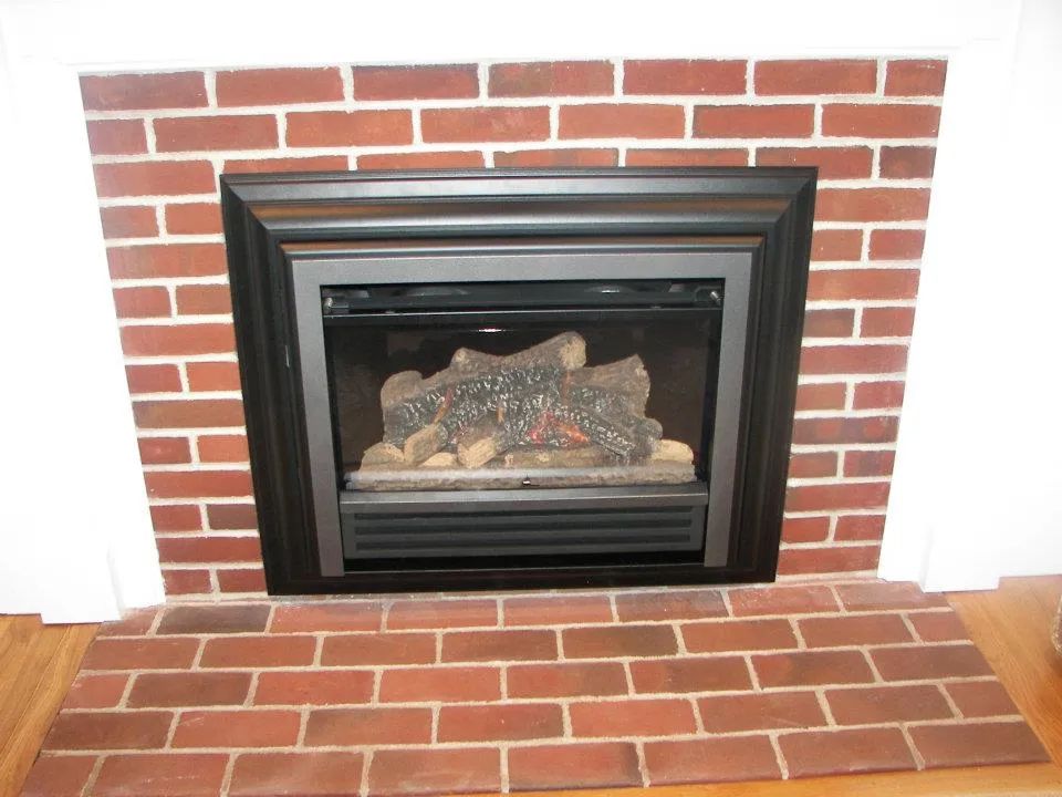 A red brick fireplace with a black frame