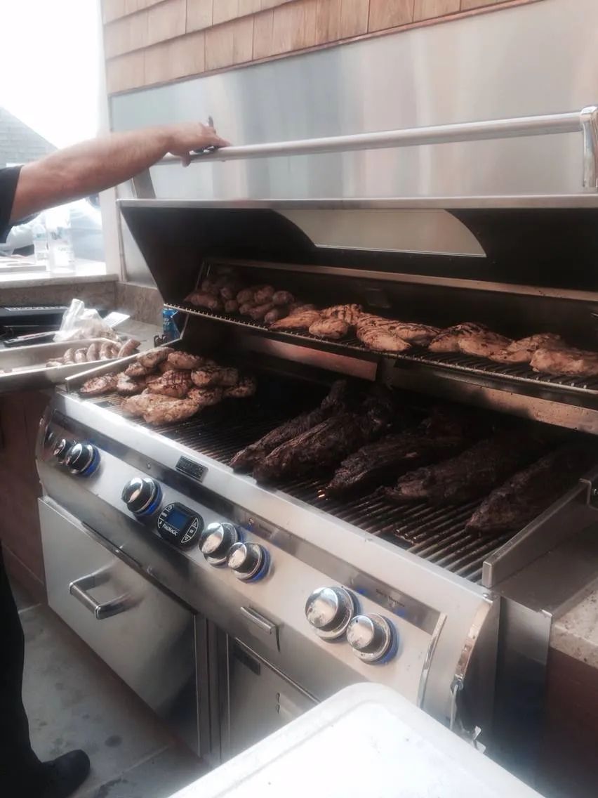 A man is cooking food on a grill in a kitchen