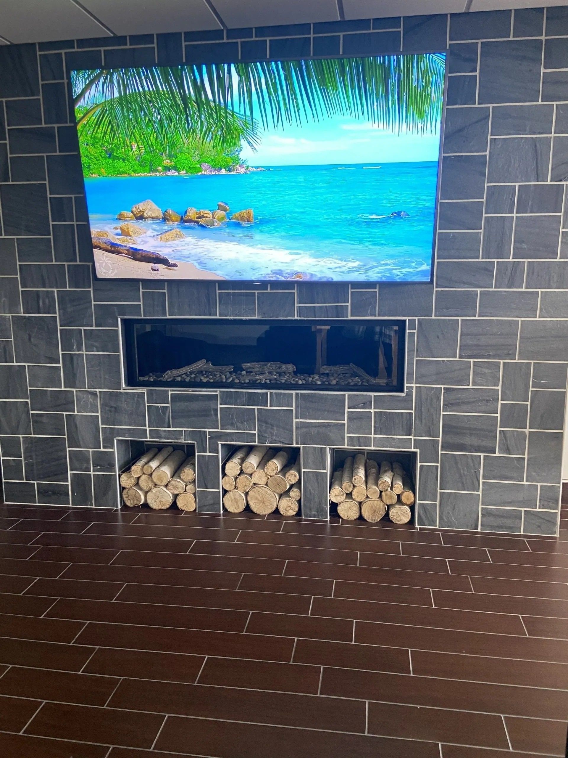 A fireplace with a picture of the ocean on the wall above it
