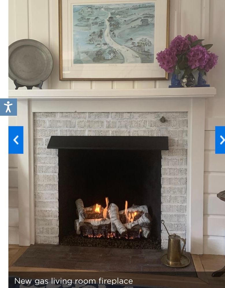 A fireplace with a picture above it that says new gas living room fireplace