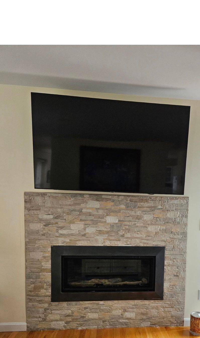 A living room with a fireplace and a flat screen tv.