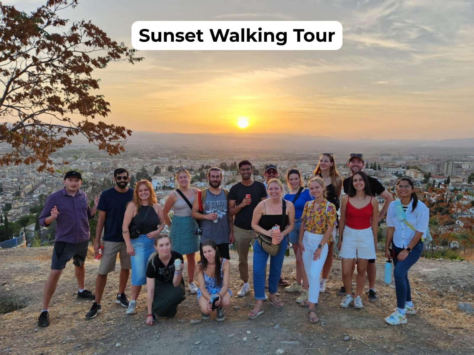 Group of people at a viewpoint with sunset and Granada in the background