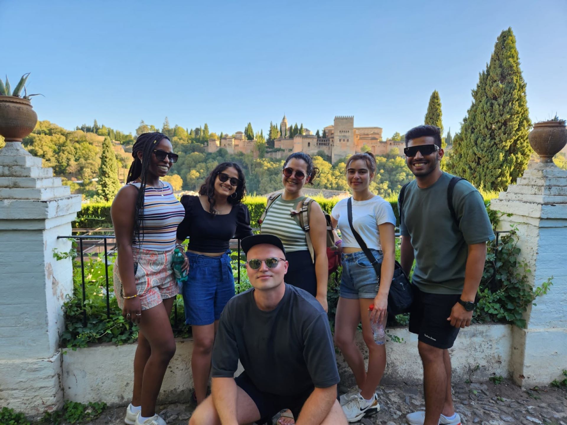 Friends smiling with the Alhambra in the background