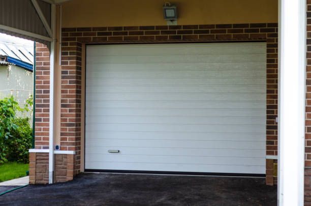 A white garage door is open in a brick building.