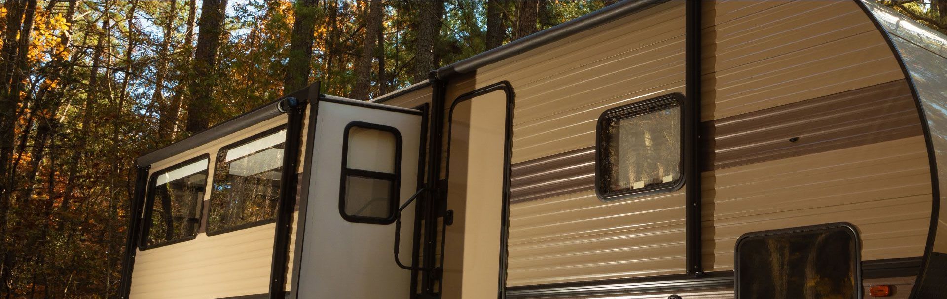 A rv is parked in a campground in the woods.