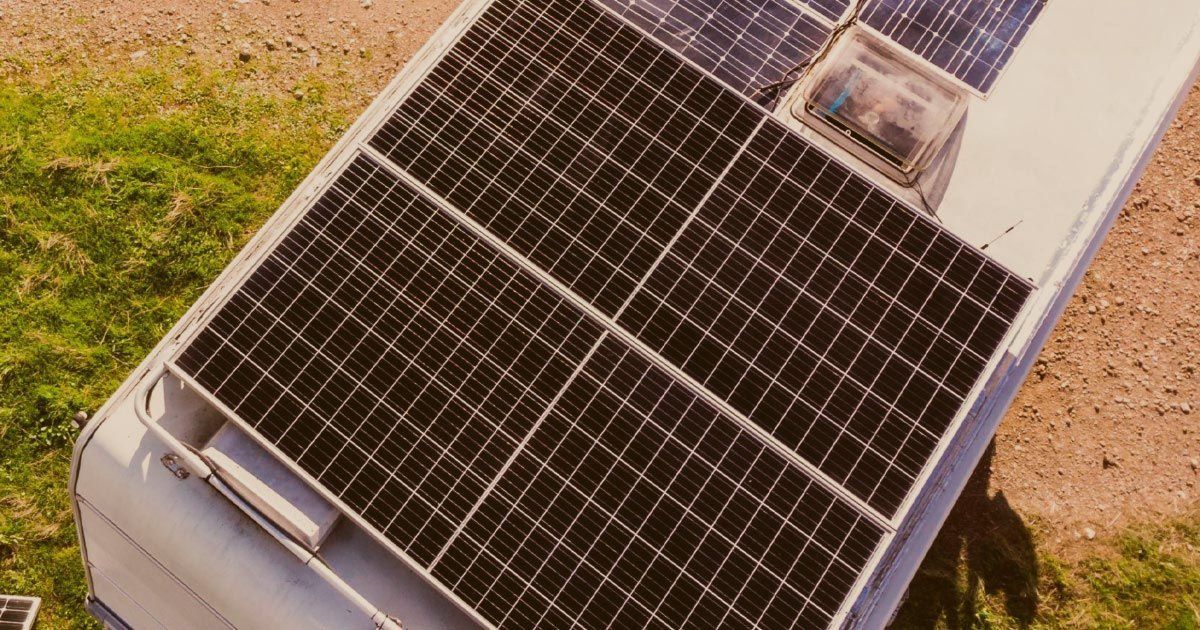 A bunch of solar panels are sitting on top of a vehicle.