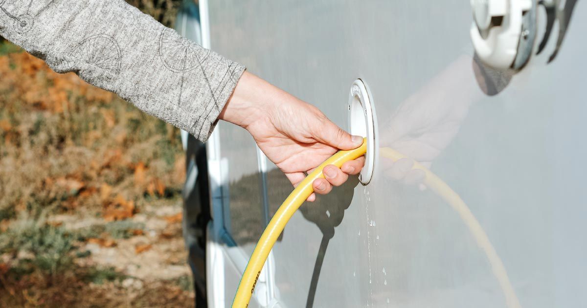 A person filling an rv water tank