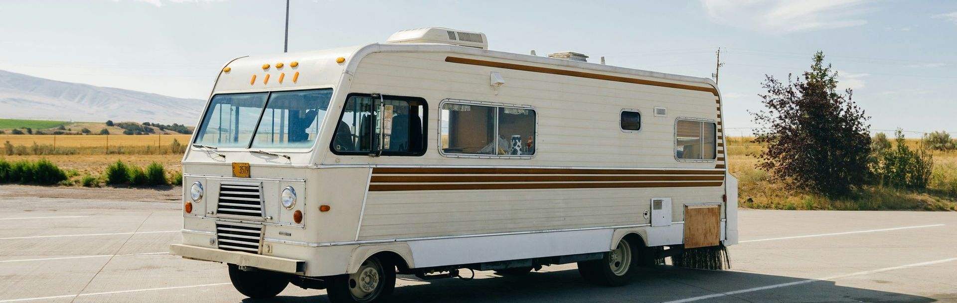 A white rv is parked on the side of the road.