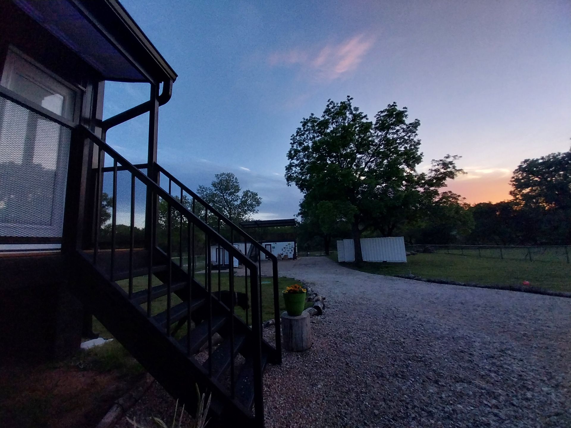 A staircase leading up to a house with a sunset in the background