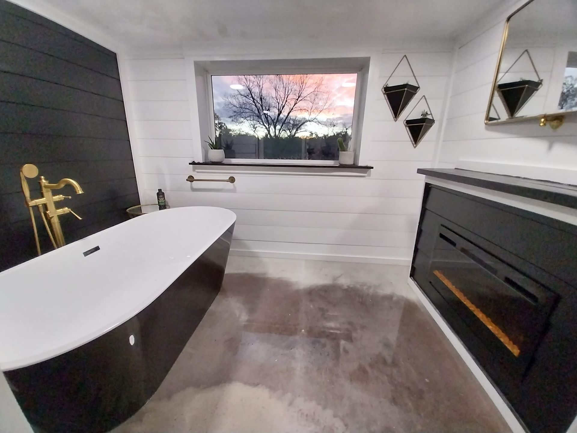 A bathroom with a black tub and a window