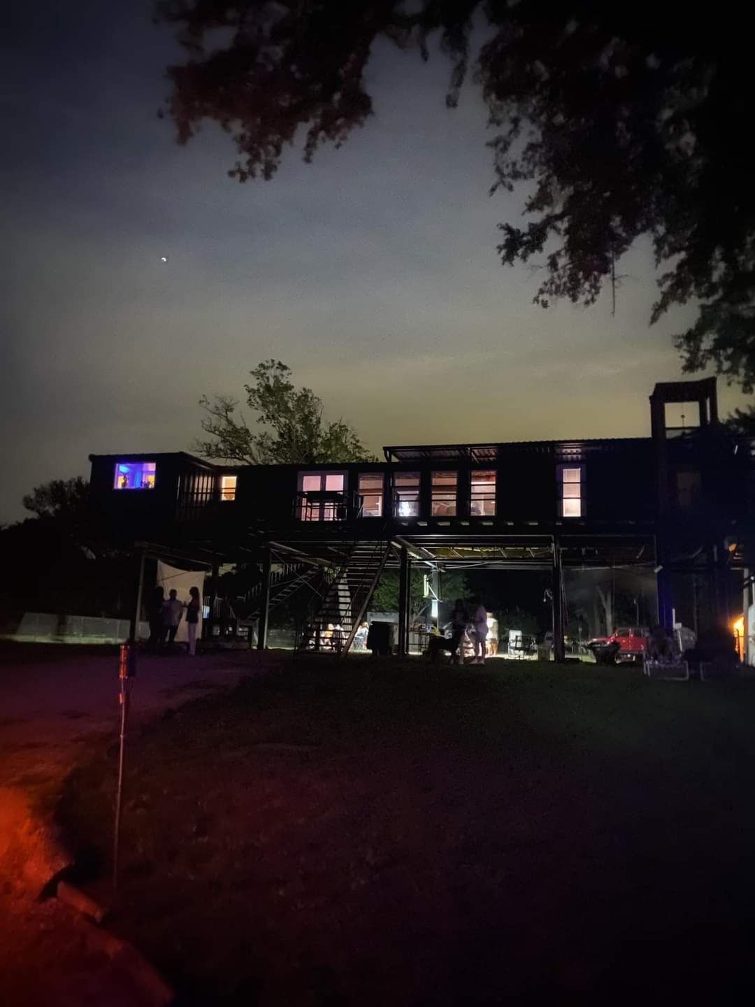 A house with a lot of windows is lit up at night