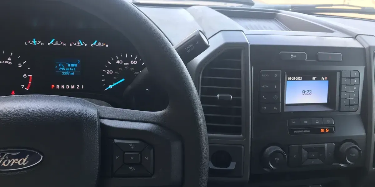 Interior of a Ford truck with a black dashboard, steering wheel, and digital display showing the speedometer.