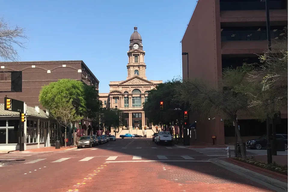 Gold scales of justice on a desk next to a laptop; a dark office chair in the background.