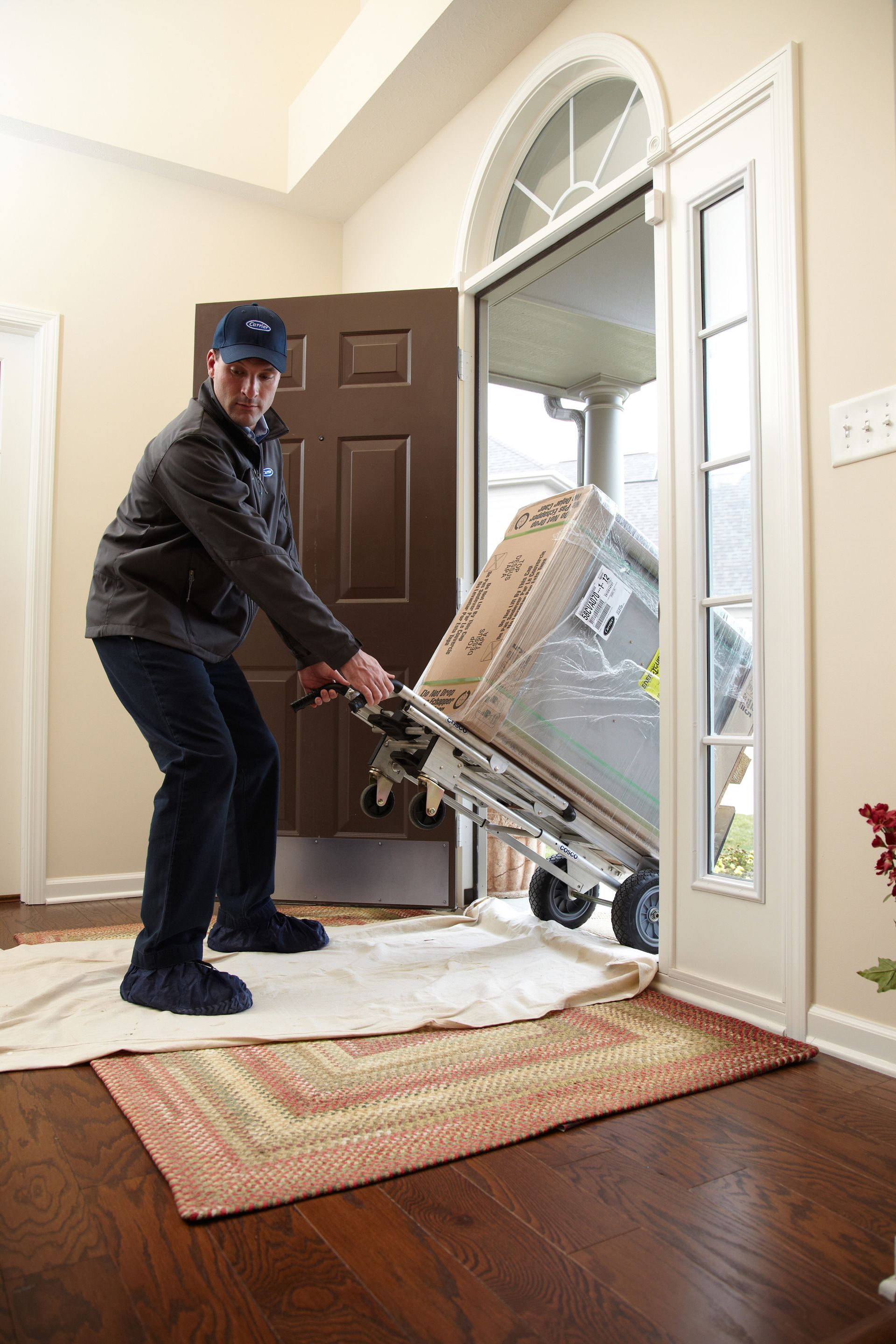 Man installing a humidifier next to a furnace in a basement setting.