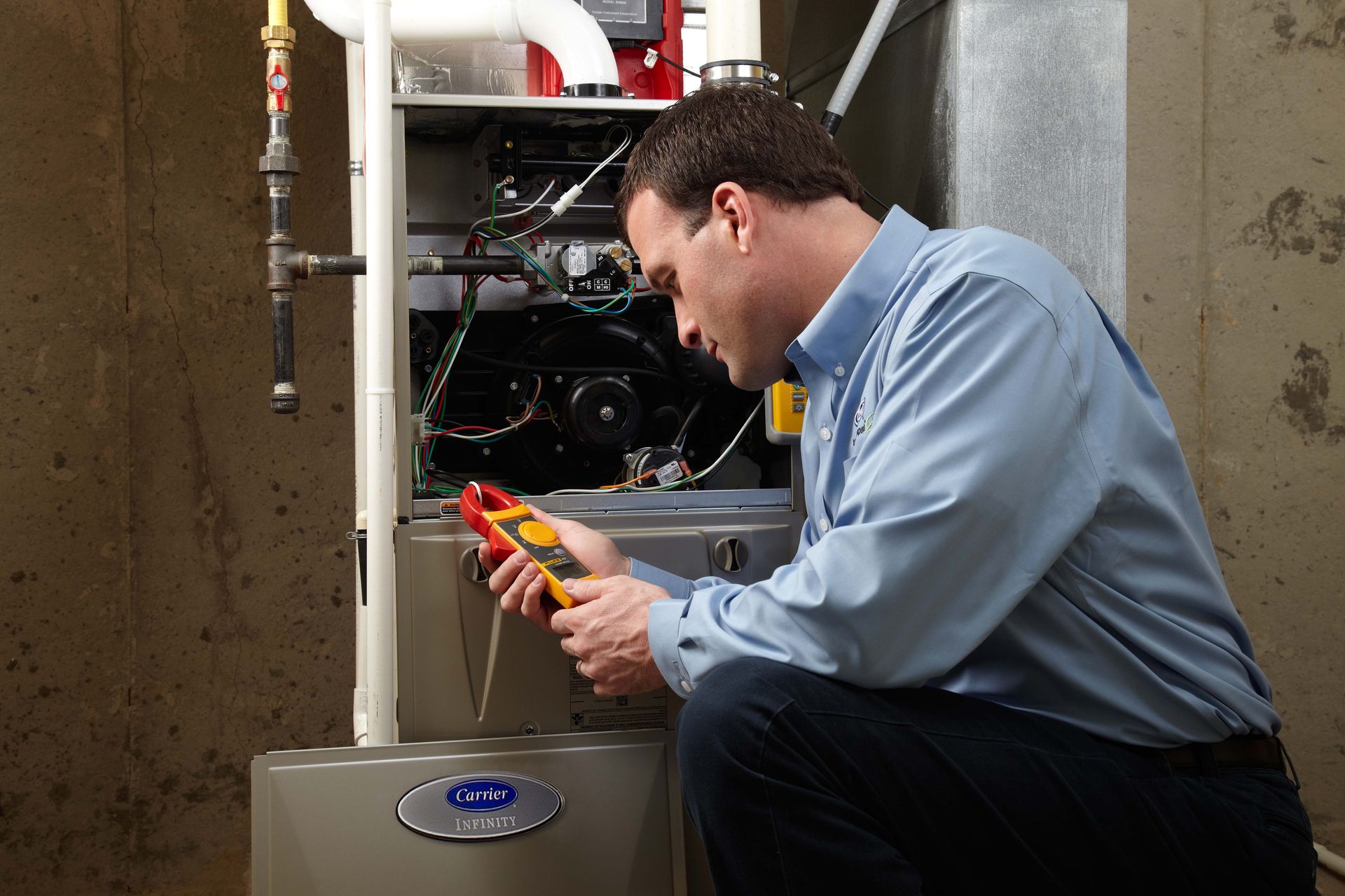 HVAC technician in blue shirt discusses thermostat with couple in a home.