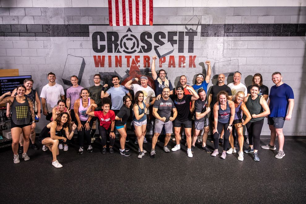 A group of people are posing for a picture in a gym.