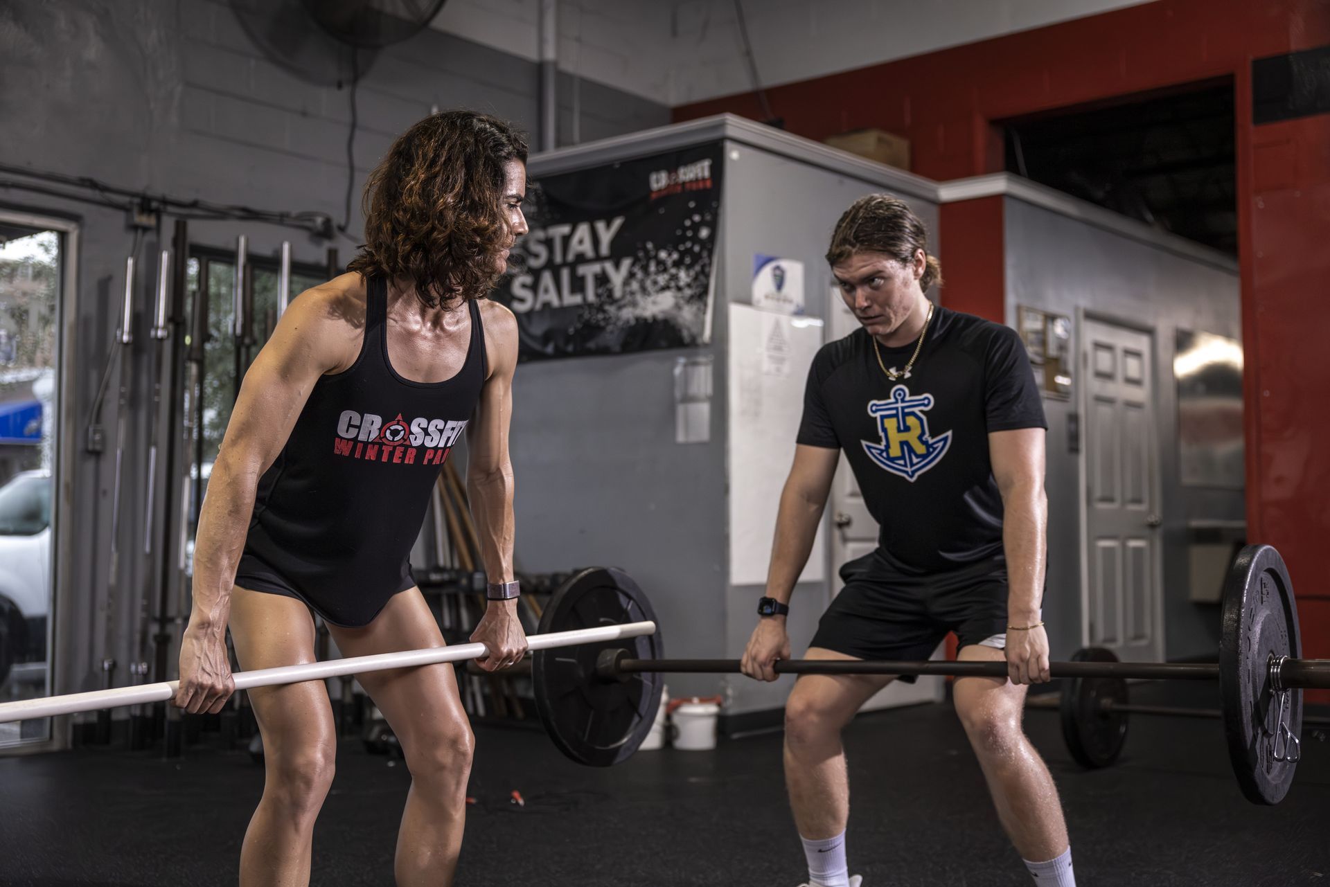 A man and a woman are lifting a barbell at the best gym in Winter Park, FL