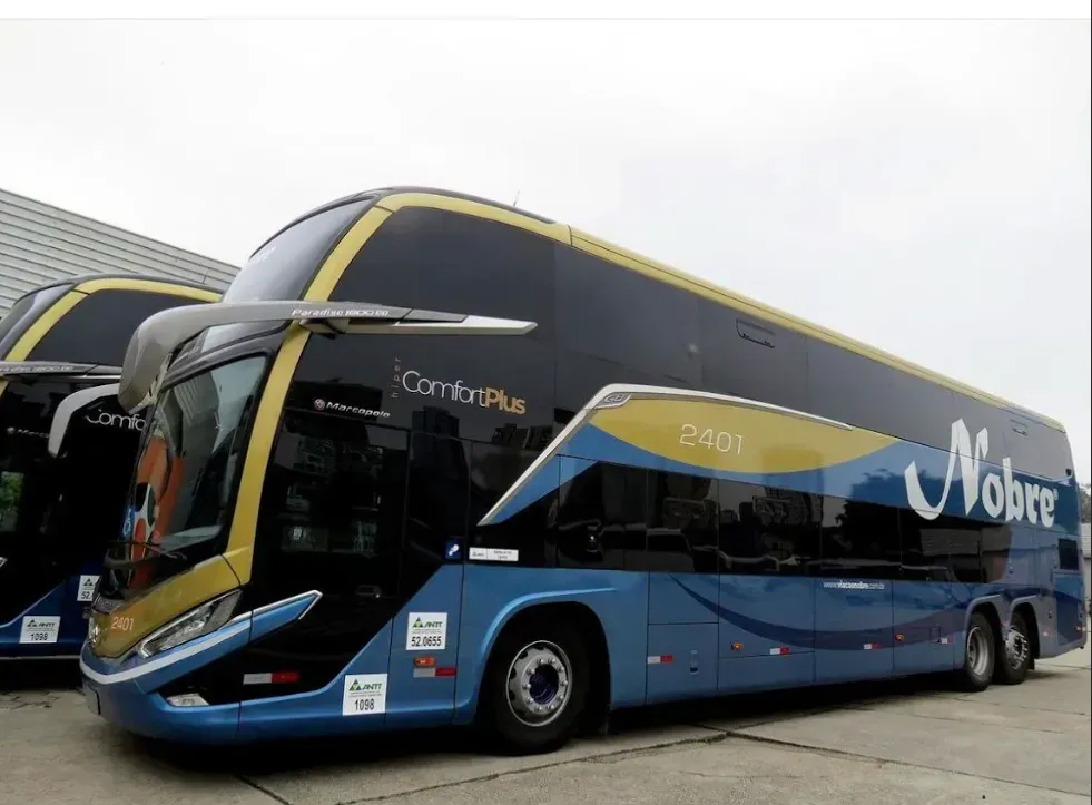 Um ônibus de dois andares está estacionado na rodoviária à noite.