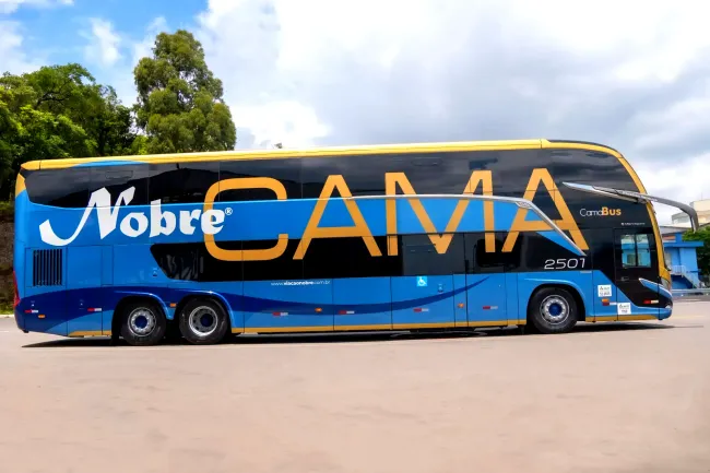 Um ônibus azul e verde na rodoviária com a palavra sul minas na lateral
