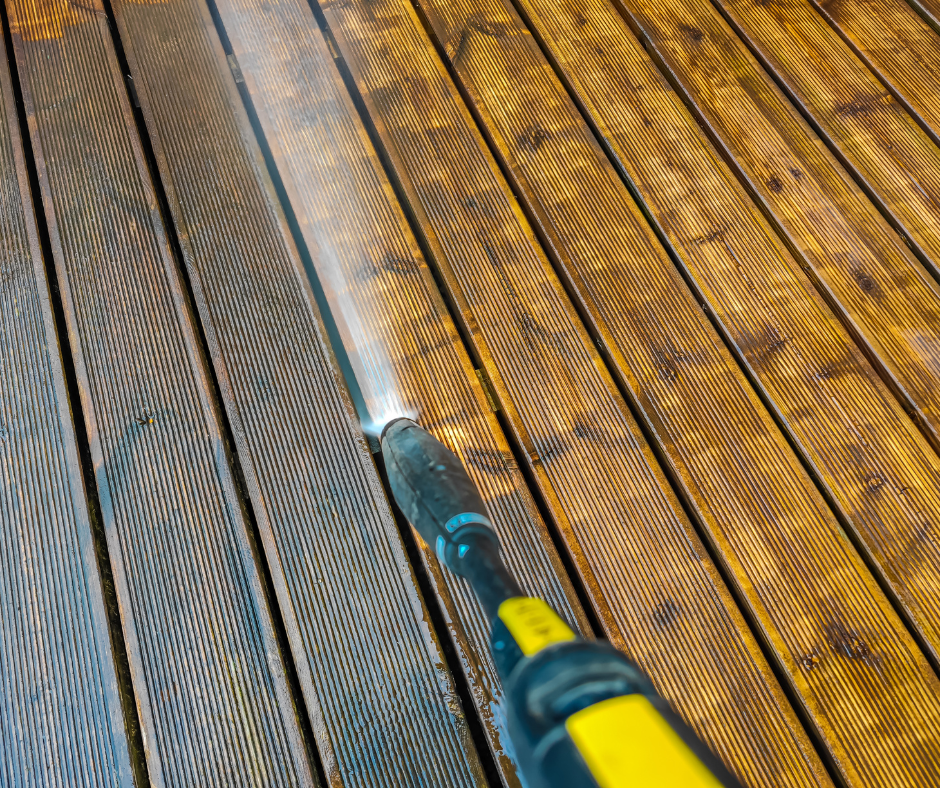 A person is using a high pressure washer to clean a roof
