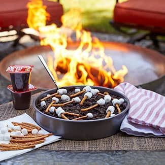 A cake is sitting on a table next to a fire pit.