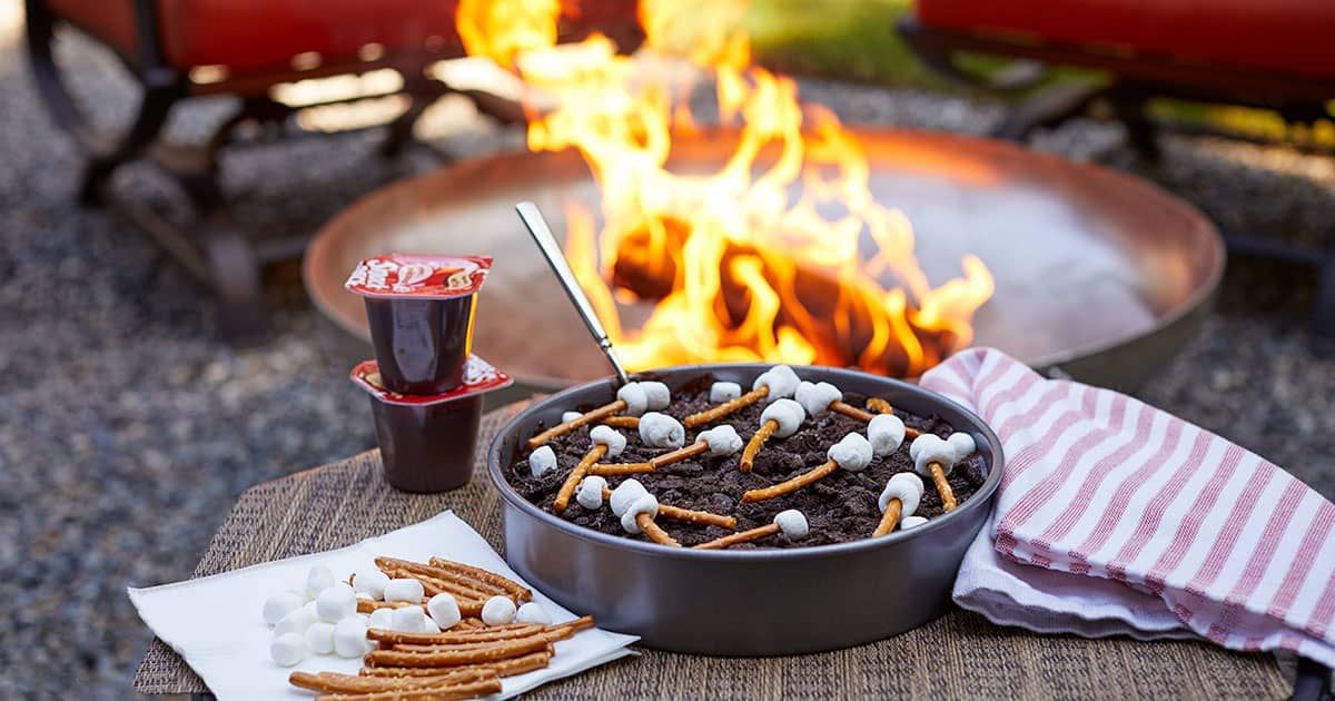 A cake is sitting on a table next to a fire pit.